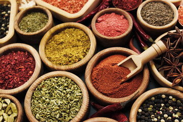 Colorful mix of herb and spice varieties: curry and coriander, turmeric and cumin, paprika and pepper, mustard and salt, cardamon and oregano and saffron. Selective focus, shallow DOF