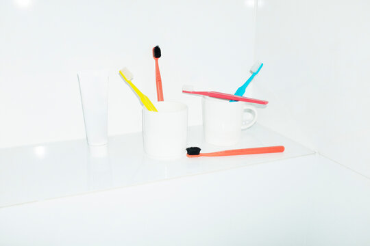Bright colorful toothbrushes on porcelain cup in toilet and flashlight