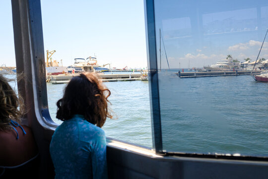 Anonymous person next to boat window with views of sea port