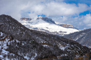 Mountain climatic resort in Armenia. Tavush region. Snow-covered hills under blue sky. Northern nature. High mountains with trees and snow on peaks. Mountain and balneological resort on winter day © Grispb