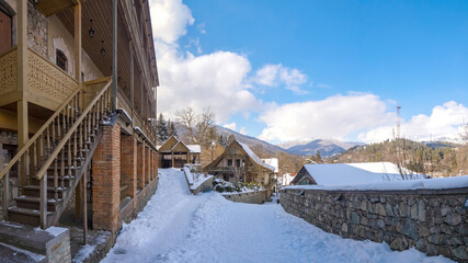 City Dilijan in Armenia. Winter resort region. Tavush region. Authentic stone buildings and fences. Winter panorama of Armenia. Snowdrifts on streets of Dilijan. Mountain climatic resort in Armenia.