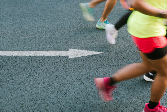 Motion blur shot of runners with arrow on the ground 