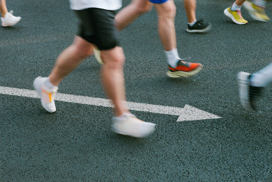 Motion blur shot of runners with arrow on the ground 