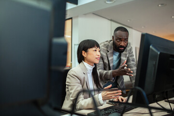 Diverse business people working together on office computer