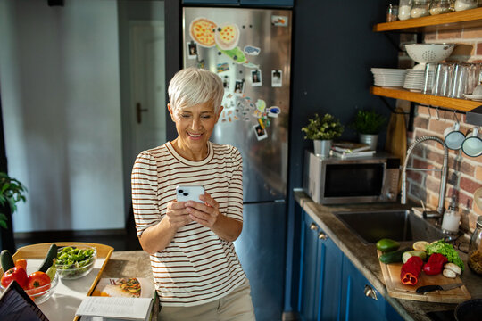 Senior woman preparing healthy meal in modern kitchen with fresh vegetables