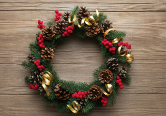 Festive christmas wreath with golden ribbon, pine cones, and red berries adds a touch of holiday cheer to a rustic wooden door
