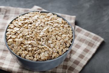Dry Oatmeal in Bowl on Linen Napkin, Close-Up
