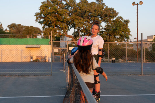 Two Sisters Rollerblading and Chatting at Sunset
