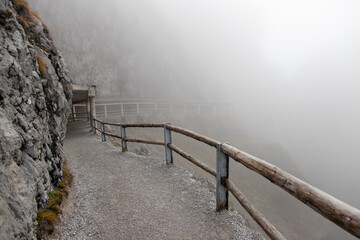 Mysterious hiking trail in the mountains hidden in the fog
