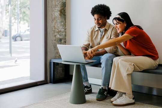 Young professionals collaborating on laptop in modern office space