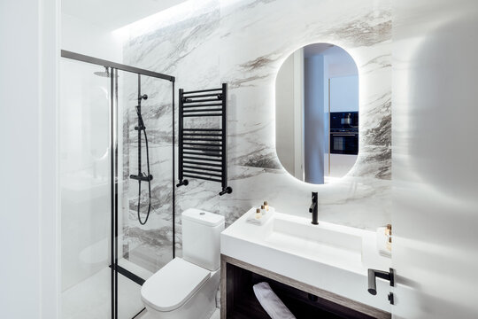 Modern Bathroom with Marble Accents and Backlit Mirror