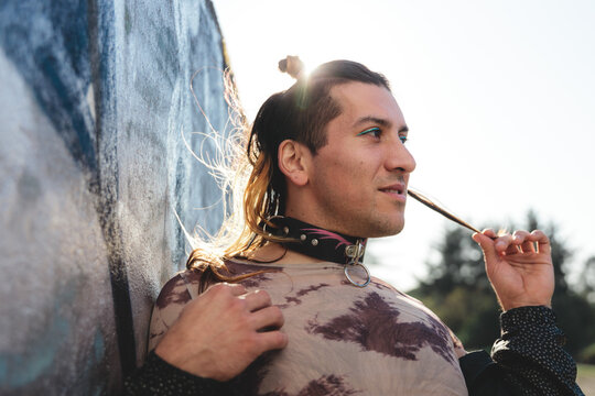 Latin Non-Binary Person Leaning Against a Graffiti Wall