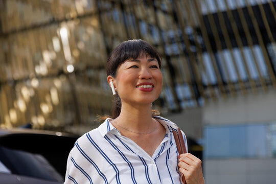 Confident young woman near building