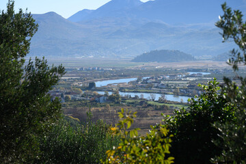 Scenic view of the Neretva River meandering through fertile fields and rural villages, framed by...