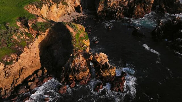 Big sur coastline sea arch with surging waves zooming in.