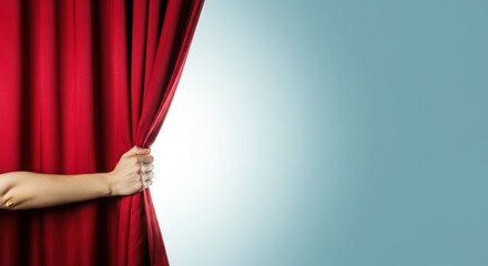 Woman's hand pulling red curtain open, revealing light blue background