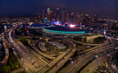 JANUARY 2024, LOS ANGELES, CA. - aerial view of LA Skyline & Convention Center at dusk showing intersection of Harbor Freeway 110 and Interstate Highway 10 with traffic