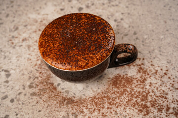 Cocoa in a beautiful glass with baked marshmallows and chocolate sprinkles on top. On a dark table and white background.