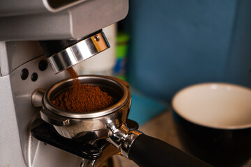 The barista monitors the dose weight to match the recipe, adjusting the grinder if necessary.