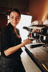 A beautiful barista girl works in a cafe. Joyful young adult man looking at the camera in a cozy cafe. Stylish waiter. Close up.