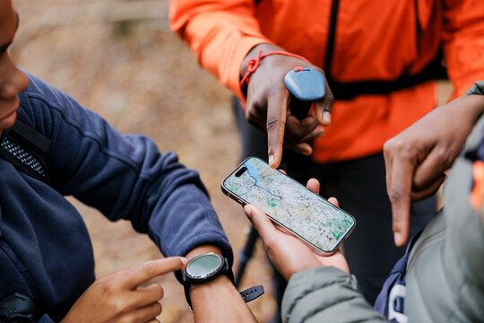 Hikers using smartphone gps app for navigation in forest