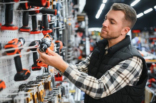 A man chooses a power tool in a hardware store