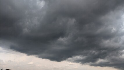 A dramatic, overcast sky with a single beam of sunlight piercing through the clouds. The dark,...