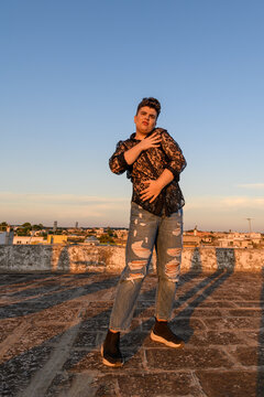 Expressive non-binary person dancing on the roof