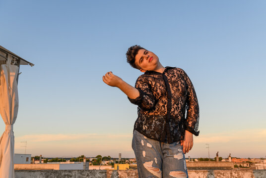 Positive non-binary person dancing on the roof