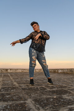 Non-binary person dancing on the roof