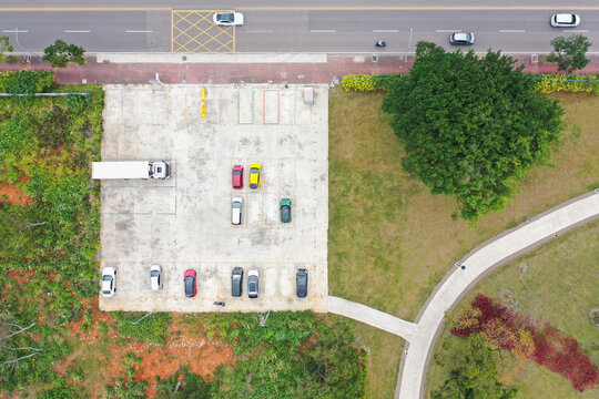 Aerial View of Urban Parking Lot Nestled Among Green Spaces and 