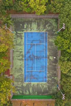 
Aerial View of Old Lone Blue Tennis Court Surrounded by Lush Green 