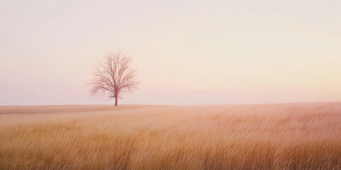 Obraz premium A serene prairie landscape at dawn with golden grasses stretching to the horizon, soft pink light in the sky, and a single tree in the distance. The peaceful setting feels timeless.