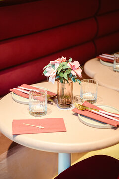 minimalist table setup in soft pink and red colors with floral decor.