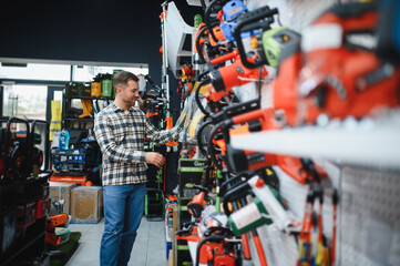Fototapeta premium A man in a hardware store choosing a tool