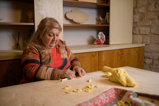 Italian senior woman making pasta orecchiette