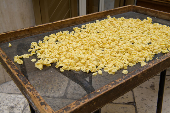 Fresh orecchiette drying on a table in the street of Bari