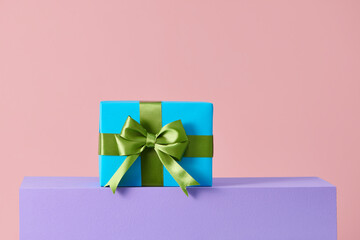 handmade present box on pink background with colors podium