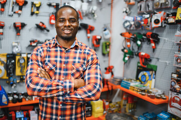 African americam man buying modern electric drill while standing in tool. Hardware construction site objects concept