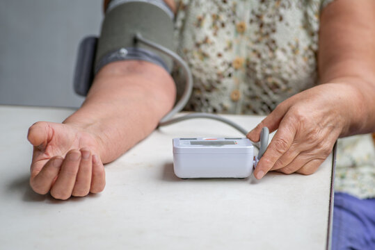 Anonymous  woman measures her blood pressure with a tonometer