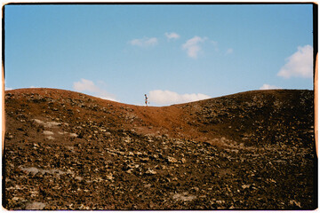 Analog image of trail running striding along a gravel path in a crater