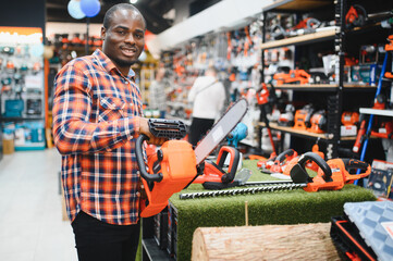 A african american man chooses a power tool in a hardware store