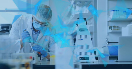 Image of glowing light trails over male scientist in laboratory