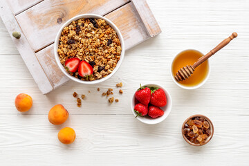 Flat lay of oatmeal granola and ingredients served on white table. Healthy breakfast