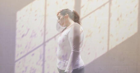 Image of shadow of window and water droplets over unhappy plus size caucasian woman