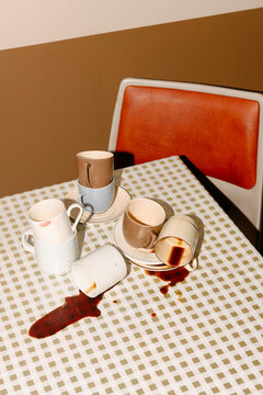 Spilled Coffee Cups on Checkered Pattern Tablecloth
