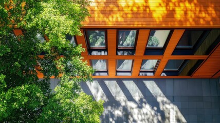 Obraz premium Aerial view of a modern building with wooden facade and surrounding greenery.