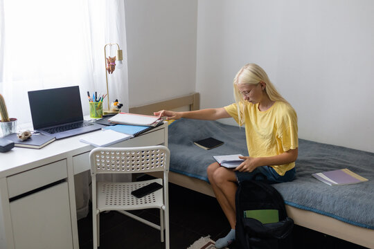 Teen girl collects textbooks according to the class schedule