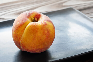 Peach on a black plate. Selective focus