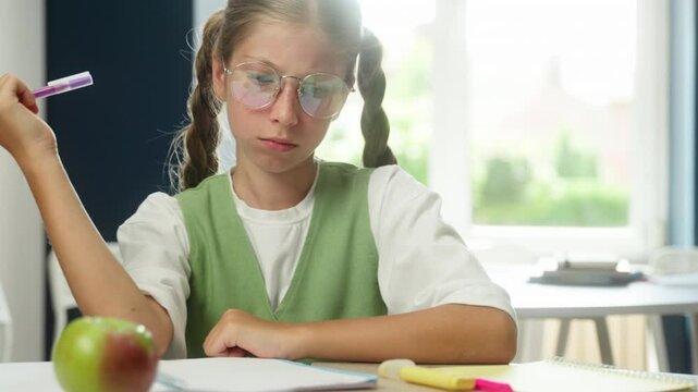 Caucasian girl pupil clever smart schoolgirl child teenager kid student learner daughter writing in classroom prepare exam test class lesson studying learning thinking write copybook school education